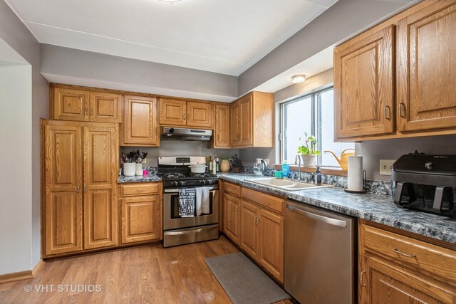 16807 81st Ave Unit 2S, Tinley Park, IL 60477 - kitchen with appliances with stainless steel finishes, under cabinet range hood, a sink, wood finished floors, and brown cabinets