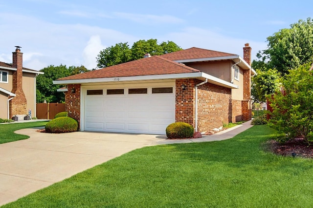 1510 W Goldengate Dr, Addison, IL 60101 - view of property exterior featuring concrete driveway, an attached garage, a lawn, brick siding, and a chimney