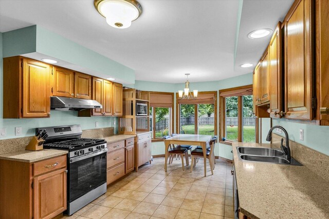1206 Wilshire Ct, Champaign, IL 61821 - kitchen with stainless steel appliances, a sink, under cabinet range hood, a chandelier, and light countertops