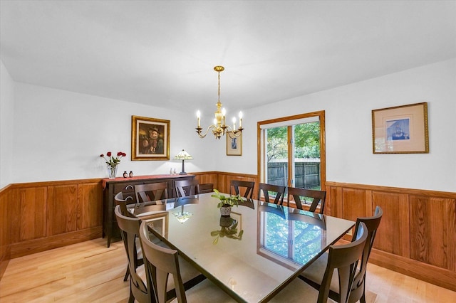 1206 Wilshire Ct, Champaign, IL 61821 - dining space featuring a wainscoted wall, light wood finished floors, wood walls, and a chandelier