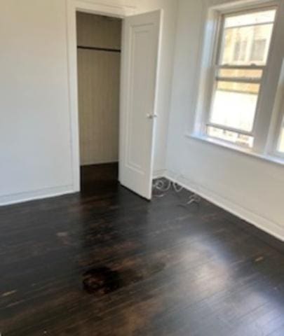 7921 S Hermitage Ave, Chicago, IL 60620 - unfurnished bedroom featuring dark wood-style floors, baseboards, and a closet