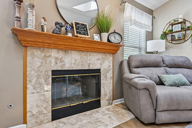 1043 San Mateo Dr, Romeoville, IL 60446 - living area featuring wood finished floors, a fireplace, a skylight, and baseboards