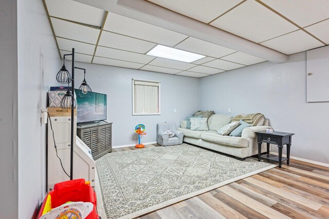 1043 San Mateo Dr, Romeoville, IL 60446 - living area featuring wood finished floors, a paneled ceiling, and baseboards