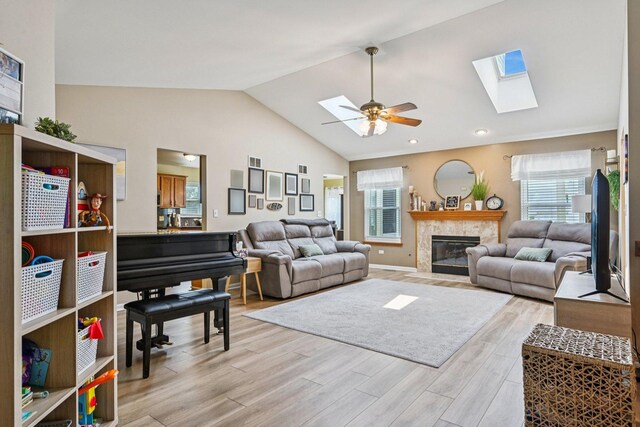 1043 San Mateo Dr, Romeoville, IL 60446 - living room with a skylight, a ceiling fan, light wood-type flooring, a fireplace, and baseboards