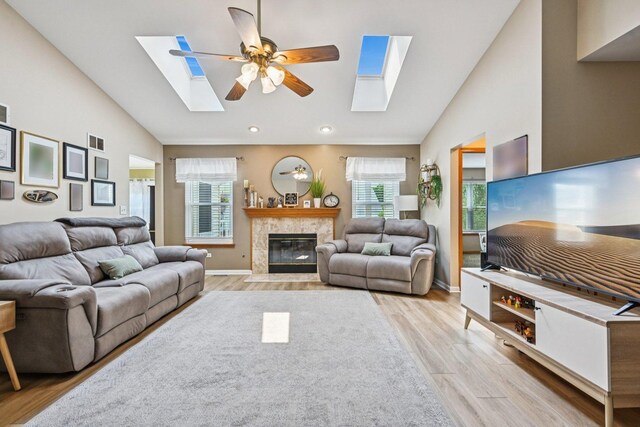 1043 San Mateo Dr, Romeoville, IL 60446 - living room with a skylight, high vaulted ceiling, light wood-type flooring, a ceiling fan, and a tile fireplace