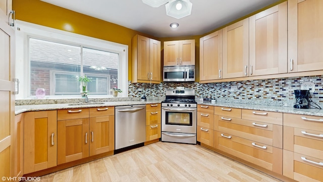 4608 W Altgeld St, Chicago, IL 60639 - kitchen with stainless steel appliances, a sink, decorative backsplash, and light stone countertops