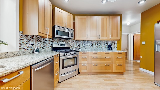 4608 W Altgeld St, Chicago, IL 60639 - kitchen featuring appliances with stainless steel finishes, backsplash, light wood-style flooring, and light stone countertops