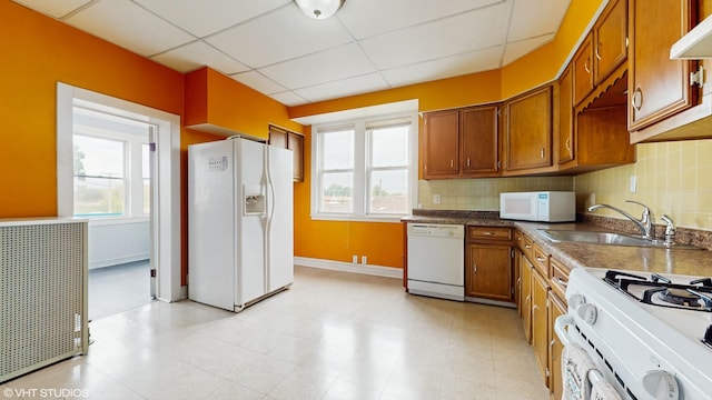 4608 W Altgeld St, Chicago, IL 60639 - kitchen with white appliances, a sink, brown cabinetry, a paneled ceiling, and backsplash