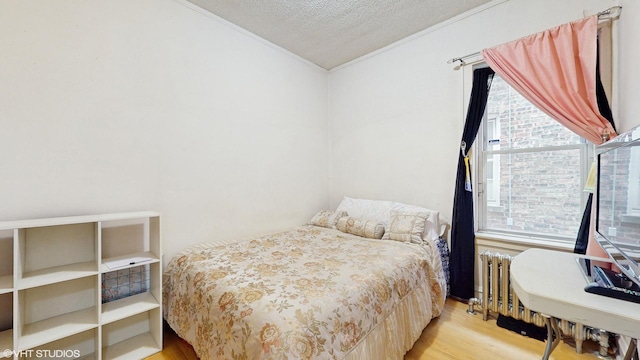 4608 W Altgeld St, Chicago, IL 60639 - bedroom featuring ornamental molding, wood finished floors, a textured ceiling, and radiator heating unit