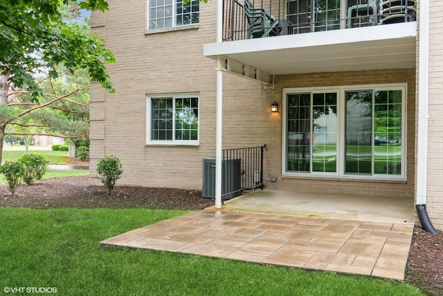 1258 Chalet Rd Unit 101, Naperville, IL 60563 - back of house featuring a balcony, brick siding, a patio area, and a lawn