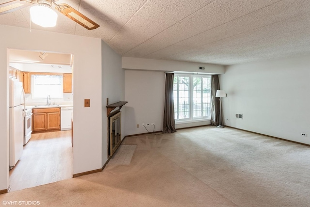 1258 Chalet Rd Unit 101, Naperville, IL 60563 - unfurnished living room featuring light colored carpet, ceiling fan, and a fireplace with flush hearth