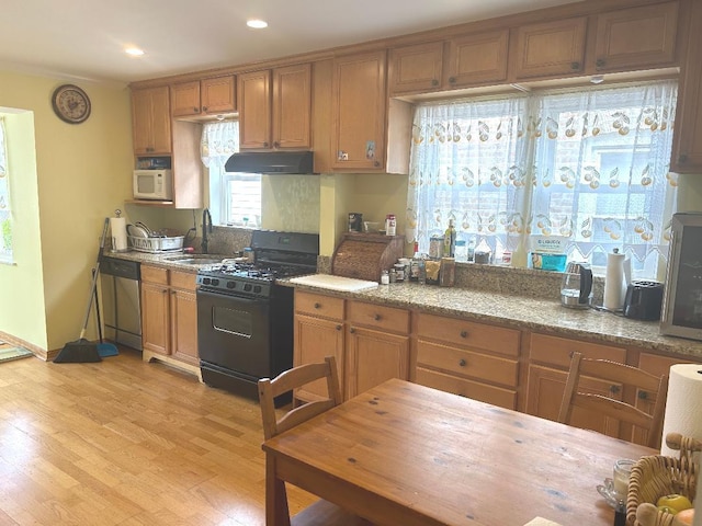 5930 W School St, Chicago, IL 60634 - kitchen featuring black gas stove, under cabinet range hood, stainless steel dishwasher, a sink, and white microwave