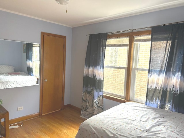 5930 W School St, Chicago, IL 60634 - bedroom featuring light wood-style flooring, multiple windows, ornamental molding, and baseboards