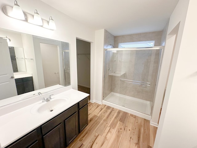 993 Celebration Dr, Aurora, IL 60504 - bathroom featuring a shower stall, vanity, wood finished floors, a spacious closet, and baseboards