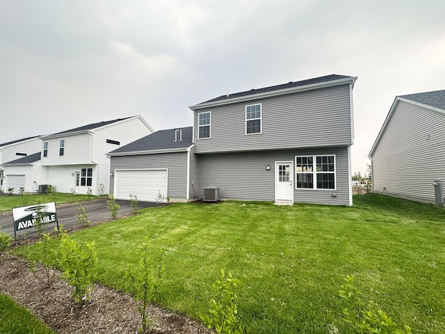 993 Celebration Dr, Aurora, IL 60504 - rear view of house with asphalt driveway, a garage, and a lawn