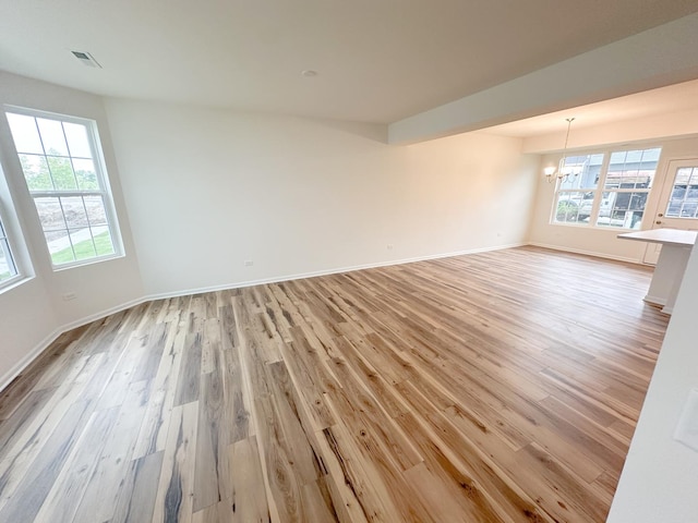 993 Celebration Dr, Aurora, IL 60504 - empty room featuring a chandelier, light wood-style floors, and baseboards