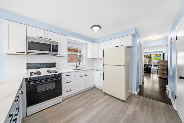 1723 W 75th Pl, Chicago, IL 60620 - kitchen with range with gas stovetop, freestanding refrigerator, stainless steel microwave, a sink, and light wood-type flooring
