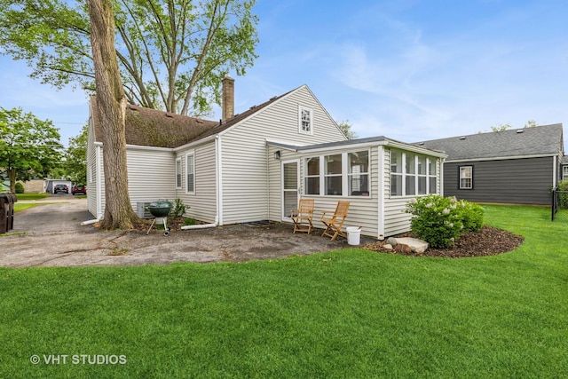 490 W Crystal Lake Ave, Crystal Lake, IL 60014 - rear view of house with a sunroom, a lawn, and a chimney