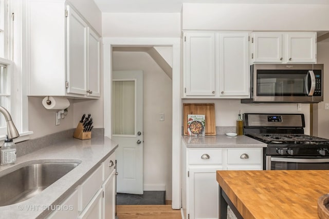 490 W Crystal Lake Ave, Crystal Lake, IL 60014 - kitchen with appliances with stainless steel finishes, a sink, wood counters, and white cabinets