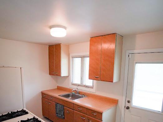 64 Ash St, Park Forest, IL 60466 - kitchen featuring a sink, brown cabinets, and light countertops