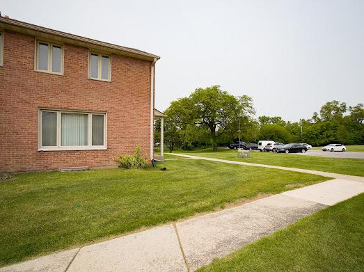 64 Ash St, Park Forest, IL 60466 - view of property exterior featuring a yard, uncovered parking, and brick siding