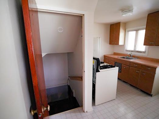 64 Ash St, Park Forest, IL 60466 - kitchen with a sink, light countertops, brown cabinetry, light floors, and white gas range