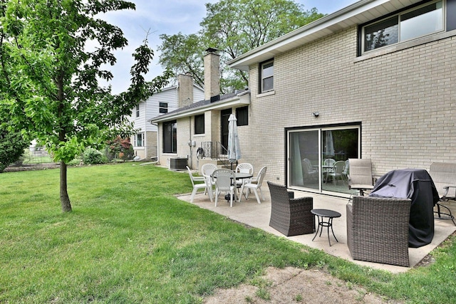 771 S Euclid Ave, Elmhurst, IL 60126 - rear view of house with brick siding, a patio area, central AC unit, a yard, and a chimney