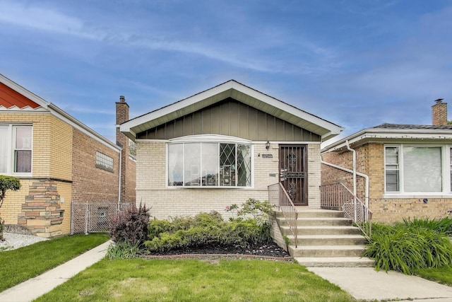 3645 W 66th St, Chicago, IL 60629 - view of front of home with brick siding, board and batten siding, and a chimney
