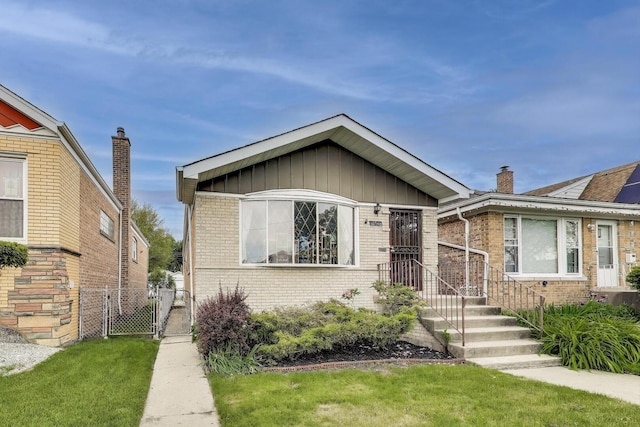 3645 W 66th St, Chicago, IL 60629 - bungalow-style house with brick siding, a gate, and board and batten siding