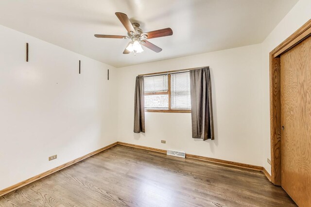 3645 W 66th St, Chicago, IL 60629 - unfurnished bedroom with wood finished floors, baseboards, a closet, and ceiling fan