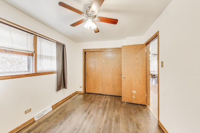 3645 W 66th St, Chicago, IL 60629 - unfurnished bedroom featuring light wood-type flooring, baseboards, a closet, and a ceiling fan
