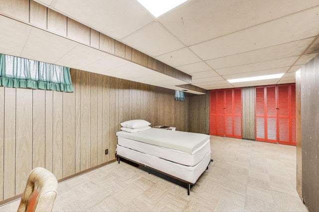 3645 W 66th St, Chicago, IL 60629 - bedroom featuring wood walls, light flooring, and a drop ceiling