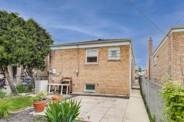 3645 W 66th St, Chicago, IL 60629 - rear view of house featuring brick siding, a patio, and a fenced backyard