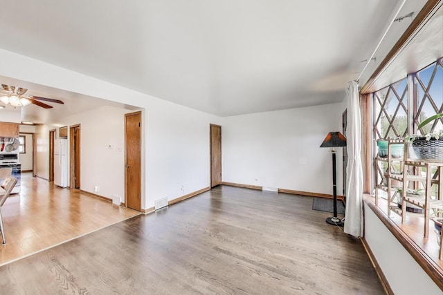 3645 W 66th St, Chicago, IL 60629 - unfurnished living room featuring wood finished floors, baseboards, and a ceiling fan
