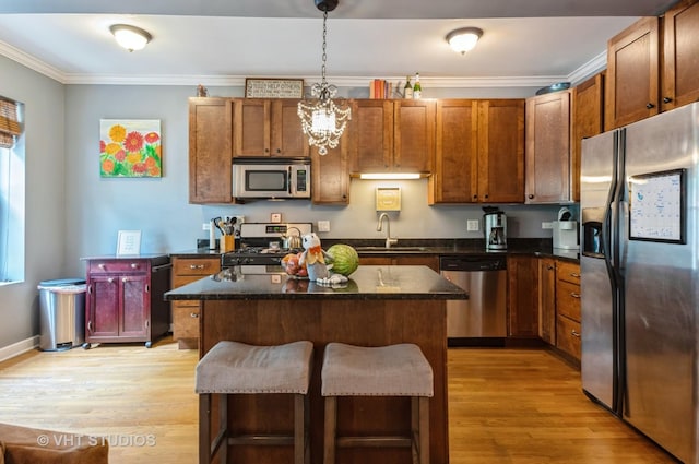 1849 W Newport Ave Unit 1, Chicago, IL 60657 - kitchen with appliances with stainless steel finishes, light wood-style floors, a kitchen island, ornamental molding, and a breakfast bar