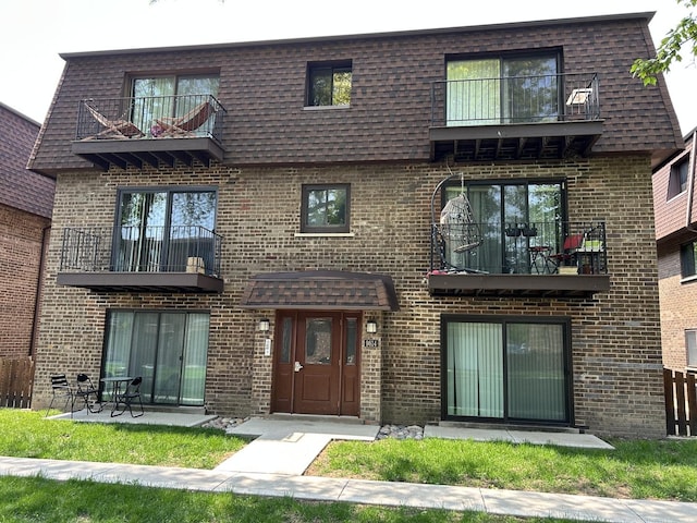 9814 Bianco Ter Unit 1B, Des Plaines, IL 60016 - view of front of property with a balcony, brick siding, and mansard roof