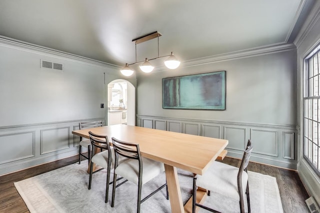 1480 Briar Cv, Wheaton, IL 60189 - dining space featuring arched walkways, crown molding, dark wood finished floors, a wainscoted wall, and a decorative wall