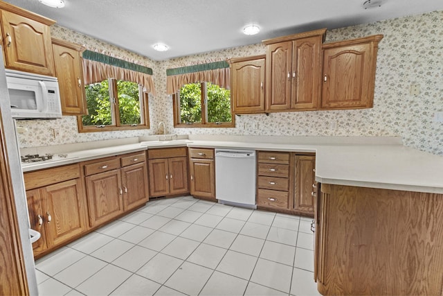 2 Lake Metonga Trl, Grant Park, IL 60940 - kitchen with white appliances, wallpapered walls, brown cabinets, light countertops, and light tile patterned floors