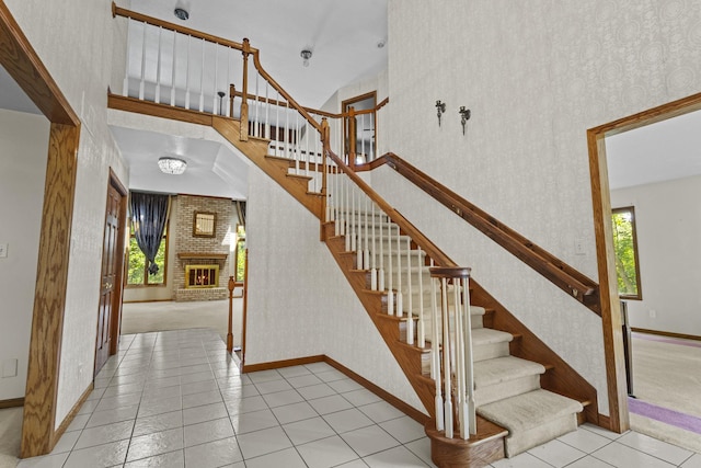 2 Lake Metonga Trl, Grant Park, IL 60940 - staircase featuring wallpapered walls, plenty of natural light, tile patterned floors, a brick fireplace, and a high ceiling