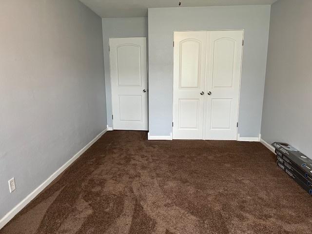114 Dante Ct, Shorewood, IL 60404 - unfurnished bedroom with dark carpet, baseboards, and a closet