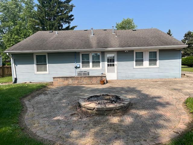 114 Dante Ct, Shorewood, IL 60404 - rear view of house with a fire pit, a shingled roof, a patio area, and central AC