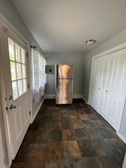 114 Dante Ct, Shorewood, IL 60404 - unfurnished bedroom featuring freestanding refrigerator, baseboards, dark stone finish flooring, and a closet
