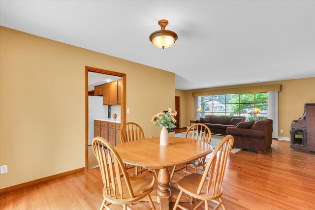 1207 W Kirby Ave, Champaign, IL 61821 - dining space with light wood-style flooring and a wood stove