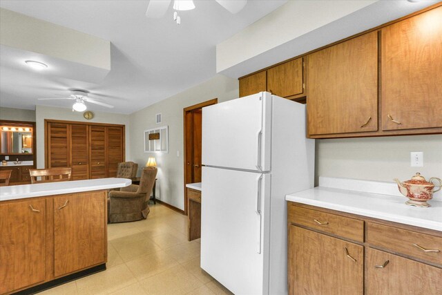1207 W Kirby Ave, Champaign, IL 61821 - kitchen featuring freestanding refrigerator, a ceiling fan, brown cabinetry, and light countertops