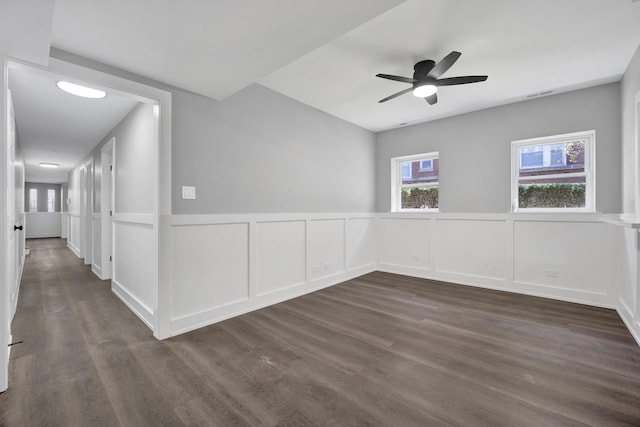 849 W Belle Plaine Ave Unit G, Chicago, IL 60613 - empty room featuring dark wood-style flooring, ceiling fan, a decorative wall, and wainscoting