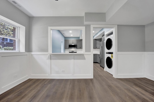 849 W Belle Plaine Ave Unit G, Chicago, IL 60613 - washroom with stacked washer / drying machine, a decorative wall, dark wood-style floors, a wainscoted wall, and recessed lighting