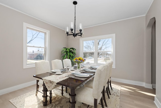 9841 Cook Ave, Oak Lawn, IL 60453 - dining room with crown molding, a chandelier, baseboards, light wood-type flooring, and arched walkways