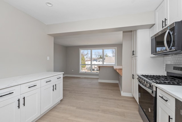 9841 Cook Ave, Oak Lawn, IL 60453 - kitchen with appliances with stainless steel finishes, tasteful backsplash, light stone countertops, and baseboards