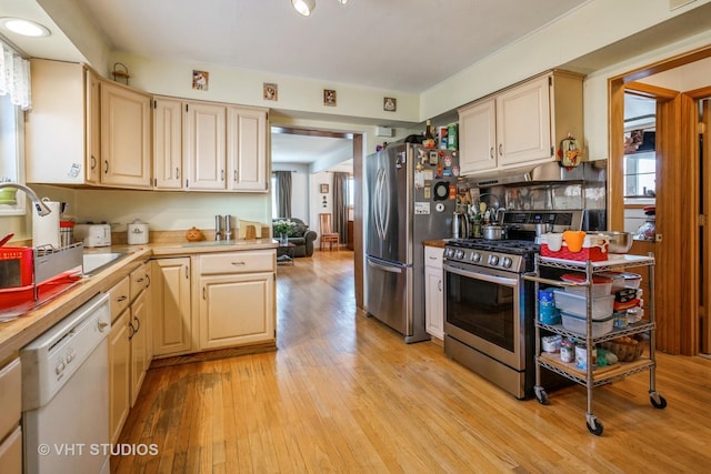 608 N Craig Pl, Addison, IL 60101 - kitchen with appliances with stainless steel finishes, light wood-style flooring, light countertops, a sink, and under cabinet range hood
