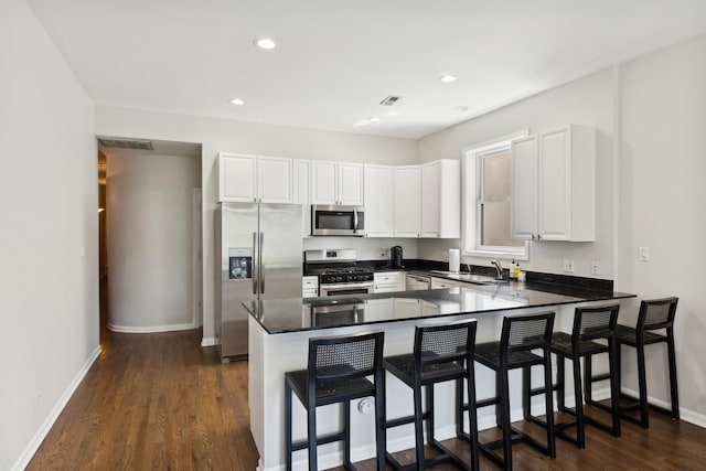 1730 W Diversey Pkwy Unit 2E, Chicago, IL 60614 - kitchen featuring stainless steel appliances, a peninsula, white cabinets, a breakfast bar area, and recessed lighting